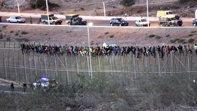 Los inmigrantes encaramados en la valla comienzan a bajarse tras 9 horas
