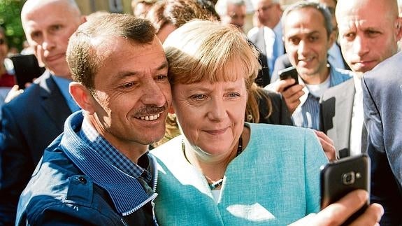 Aplausos y 'selfies' con Merkel en un centro de refugiados