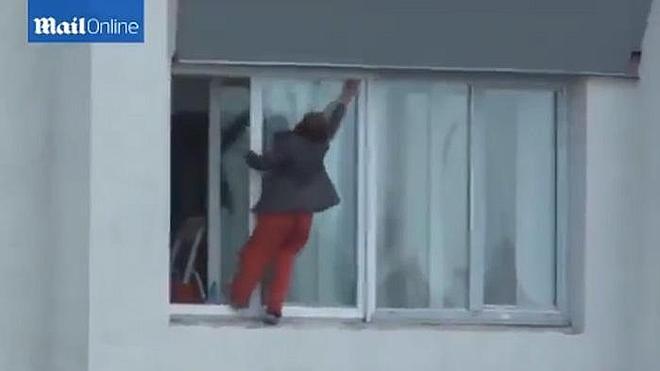 Una mujer arriesga su vida por limpiar los cristales de una vivienda en un noveno piso