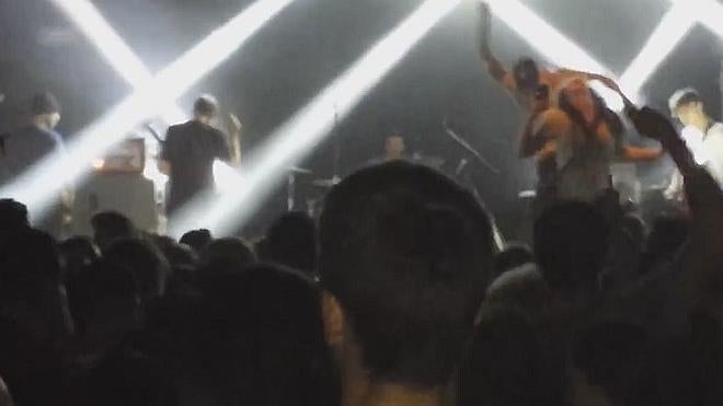 El cantante de un grupo punk tira del escenario a una fan de una patada
