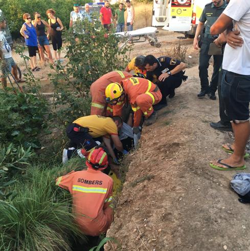 Los bomberos desvían el agua de una acequia en Rafelguaraf para rescatar a una anciana