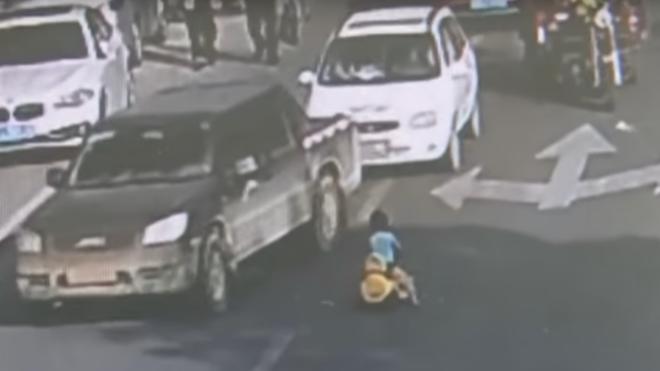 Un niño se mete en la carretera con su coche de juguete