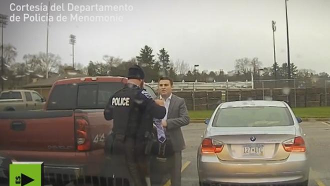 Un policía ayuda a un joven con el nudo de la corbata